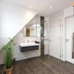 Badezimmer mit Dusche, Waschbecken und Sauna