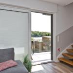 Wohnbereich mit Blick auf den See, Terrasse und Treppe.