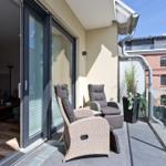 Terrasse mit zwei Liegestühlen und Blick auf Backsteinhaus