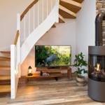 Treppenhaus mit Fernseher und Kaminofen an Backsteinwand