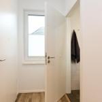 Haus mit Eingangsbereich, Tür, Fenster und Thermostat an der Wand.