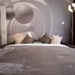 Ein Bett mit Kissen und einer Wanddekoration mit Kreisen.