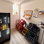 Kühlschrank mit Getränken und Flaschenregale an der Wand.