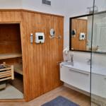 Bad mit Sauna, Waschbecken und Spiegel