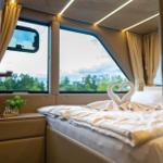 Schlafzimmer mit Bett, Fenster und Handtuchschwanen