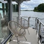 Terrasse mit zwei Stühlen und Blick auf Wasser und Ufer.