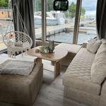 Wohnbereich mit Sofa, Hängesessel und Blick auf den Hafen.