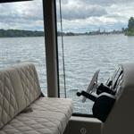 Sitzbereich mit Steuerung und Blick auf Wasser und Ufer.