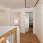 Flur mit Holzboden und Türen zu Schlafzimmer und Bad.