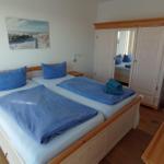 Schlafzimmer mit Doppelbett, Kleiderschrank und Wandbild