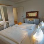 Zimmer mit Doppelbett, Kleiderschrank und Schminktisch mit Spiegel.