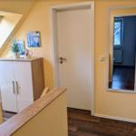 Dachgeschoss mit Dachfenster, Schrank und Spiegel an der Wand.