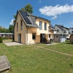 Haus mit Garten, Terrasse und Holzsauna. Solaranlage auf Dach.