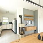 Küche mit Arbeitsplatten und Wohnbereich mit Sofa und Holztisch