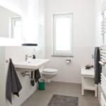 Badezimmer mit Waschbecken, Toilette, Dusche und Heizkörper.