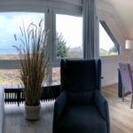 Living and dining area with large window and sea view.