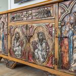 Antique cabinet with religious carvings and colored wood