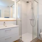 Modern bathroom with shower, sink, and toilet.