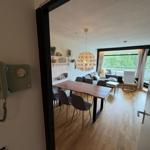 Ein Esszimmer mit Tisch und Stühlen, ein Wohnbereich mit Sofa und Balkon.