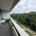 Terrasse mit Tisch und Stühlen, Blick auf Wald und Himmel.