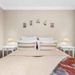 Schlafzimmer mit Bett, Nachttischen und Wanddekoration BEACH.