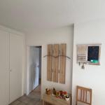 Eingangsbereich mit Kleiderhaken, Tisch und Stuhl. Hintergrund: Tür und Schrank.