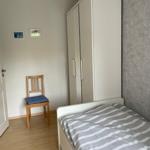 Schlafzimmer mit Bett, Kleiderschrank und Stuhl