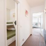Flur mit Blick in Schlafzimmer mit Doppelstockbett und weiterem Raum mit Fenster.