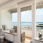 Wohnzimmer mit Balkon und Blick auf Wasser