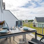 Terrasse mit gedecktem Tisch und Blick auf Grünflächen und Häuser