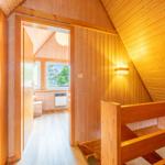 Holzgetäfelte Türöffnung zu einem Schlafzimmer mit Fenster und Klimagerät.