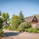 Wohnhaus mit Garten und Zufahrt unter blauem Himmel.