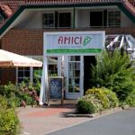 Italienische Pizzeria mit Sitzbereich im Freien und grüner Umgebung.