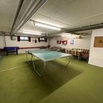 Raum mit Tischtennisplatte, Foosballtisch und Sitzgelegenheiten.