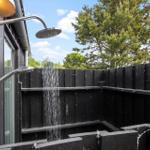 Außen-Dusche mit Regenrinnenabfluss und schwarzen Holzwänden im Garten