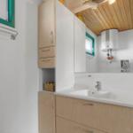 Badezimmer mit Waschbecken, Spiegelschrank und Holzdecke