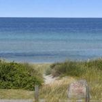 Privatstrandhaus mit Blick auf das Meer und grüne Dünen.