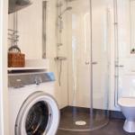 Badezimmer mit Dusche, Toilette und Waschmaschine.