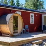Roter Holzausbau mit Sauna aus Eiche und Terrasse mit Stühlen.