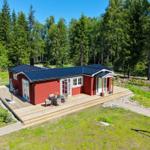 Rotes Ferienhaus mit Terrasse und Grillplatz im Wald