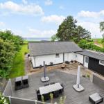 Haus mit Terrasse, Garten und Meerblick. Gartenmöbel und Sonnenschirme sind vorhanden.