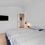 Schlafzimmer mit Bett, Fernseher und Kleiderhaken im Anschluss