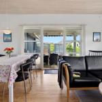 Wohn- und Essbereich mit Tisch, Stühlen und Sofa. Durchgang zur Terrasse mit Blick auf Garten.