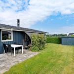 Ein blauer Ferienhaus mit Terrasse, Garten und Grillplatz.