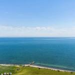 Weitläufiger Blick auf das Meer mit Strand und Booten