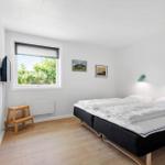 Ein Schlafzimmer mit Bett, Fenster, Wandlampen und Holzboden.