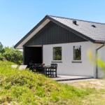 Moderne Villa mit Terrasse und Garten. Schwarz-weißes Design unter blauem Himmel.