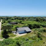 Haus mit Terrasse in grüner Umgebung, Blick auf das Meer.