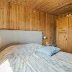 Schlafzimmer mit Holzwand, Bett und Kleiderschrank.