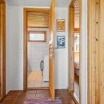Flur mit Holztüren, Waschmaschine im angrenzenden Raum und Blick in Schlafzimmer.